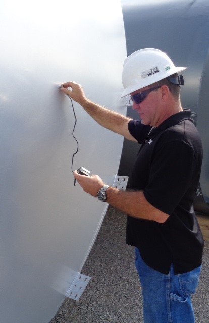Worker uses ultrasonics to test a tank