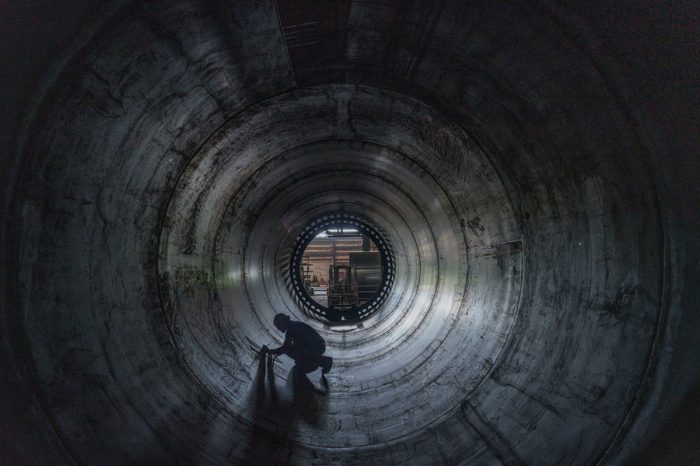 Engineer working on interior of storage tank.